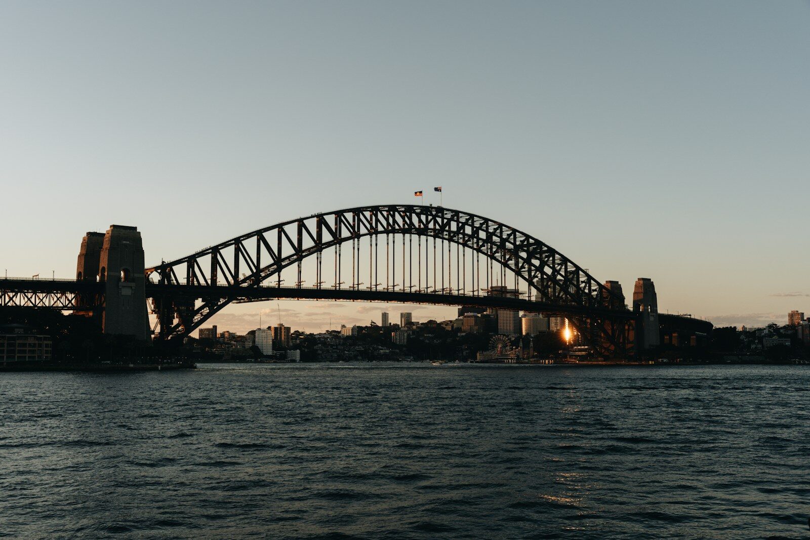 Sydney harbour bridge at sunset with calm water