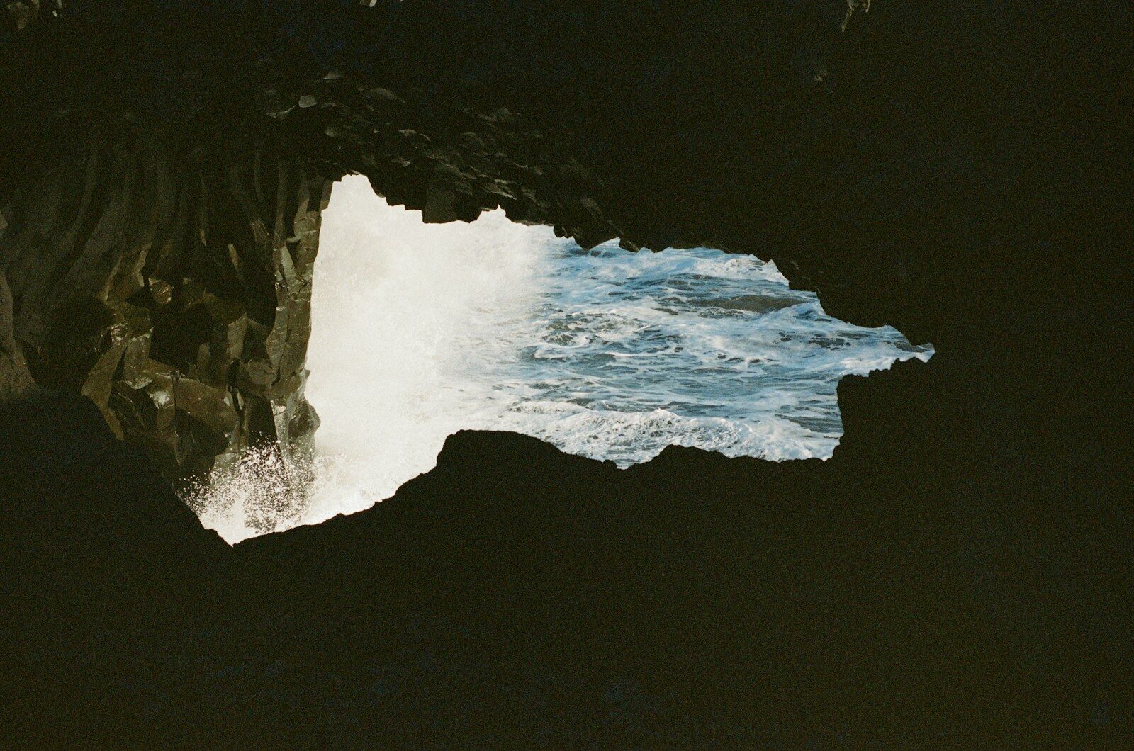 Ocean waves crashing into a dark sea cave.